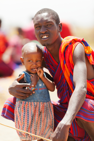 Amboseli, Kenya - February 07, 2012 : Portrait of a young masai man with his son - a little boy, selling jewelry to visitors in masai village in Amboseli national parkのeditorial素材