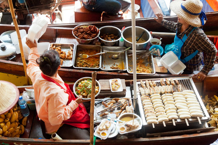 Damnoen Saduak, Thailand - March 21, 2011 : Two Thai women selling freshly cooked food on a boat in Damnoen Saduak Floating Marketのeditorial素材