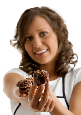 Young woman with chocolate muffin. Isolated on white background. Focus on muffins.の写真素材
