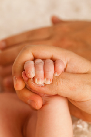 Father holding hand of a newborn babyの写真素材