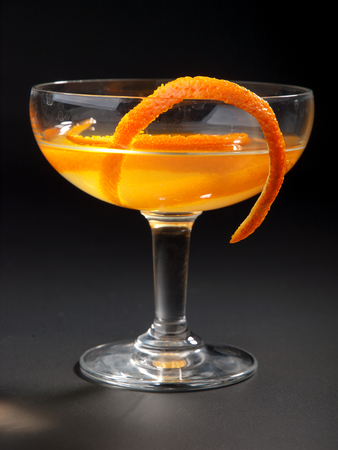 Satan Whiskers cocktail isolated on black background. Made from 1 oz gin, 1/2 oz orange liqueur, 1 oz dry vermouth, 1 oz sweet vermouth, 1 oz orange juice, 2 dashes orange bittersの写真素材