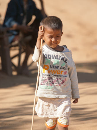 Bagan, Myanmar - February 26, 2011 - Burmese kid playing around in the dust on a sunny dayのeditorial素材