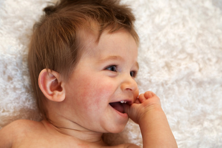 Portrait of a one year old boy with blue eyes and blonde hair. Horizontal shot