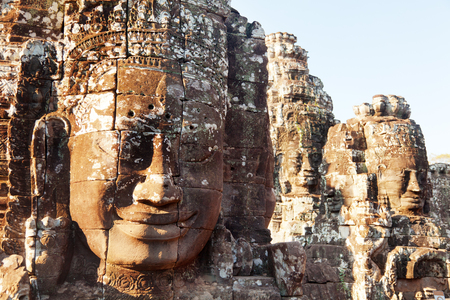Dramatic view at sunset of one of the many large stone carved faces of Bayon Temple in Angkor Thom, Angkor district, Siem Reap, Cambodiaの写真素材