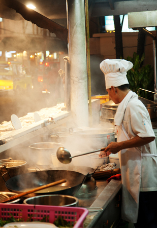 Phuket, Thailand - March 14, 2011 - Chef cooking in a street restaurant in thailandのeditorial素材
