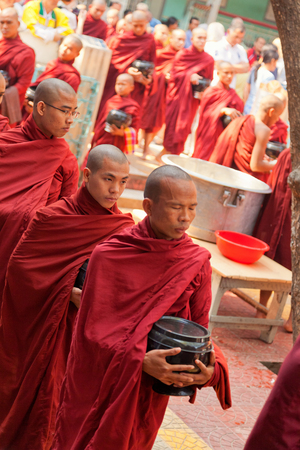 Mandalay, Myanmar - February 27, 2011 - Monks from Mahagandayone monastery gathering for their morning meal. All of them carry special buckets in which they collect food prepared from the local peopleのeditorial素材
