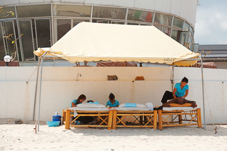 Koh Samui, Thailand - March 13, 2011 : Tourist receiveing beach massage from young thai women on Chaweng Beachのeditorial素材