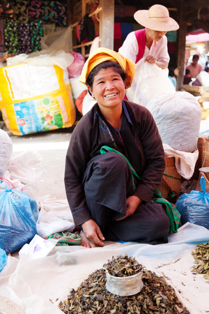 Heho, Myanmar - March 02, 2011 : Senior Burmese woman selling herbs at five-day market while sitting on the groundのeditorial素材