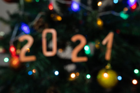 Blurred Christmas background. Decorated Christmas tree with red and yellow balls close-up. New Year background with numbers 2021. Christmas garlandsの写真素材