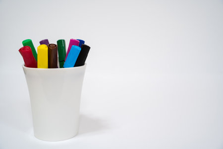 Set of multicolored markers in a white cup on whiteの写真素材