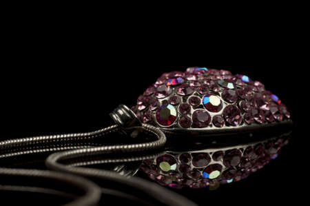 Diamond necklace with heart shape and reflection on black backgroundの写真素材