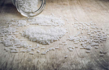 Rice in shape of heart on wood table close up