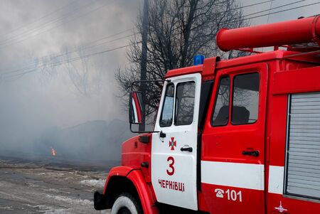 Fire Engine with sirens and blue lights with fire on background.のeditorial素材