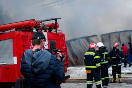 Fire Engine with sirens and blue lights with fire on background.