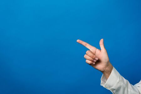 Young woman show something on the left. pointing to the side . Presenting product. With copyspace Horizontal photoの写真素材