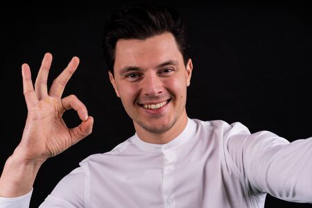 guy doing selfie and shows that all is well. smiling. close-upの写真素材