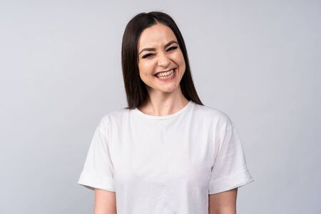 Girl in white t-shirt looking directly at the camera and smiling very emotionalの写真素材