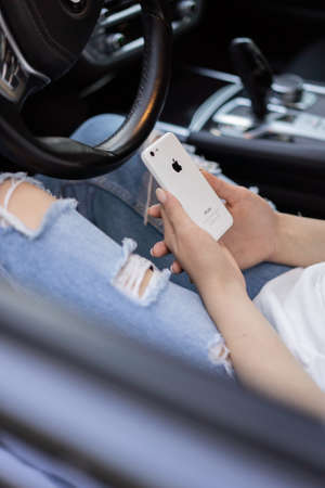 Chernivtsi, Ukraine - may 25, 2020: Woman holding iphone from apple in hands while sitting in the carのeditorial素材
