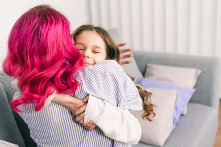 the girl hugs her mother tightly and enjoys itの写真素材