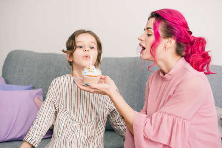 girl blows out a candle on her cake on her birthdayの写真素材