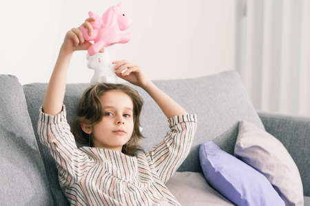 girl playing with her unicorns in her bright roomの写真素材