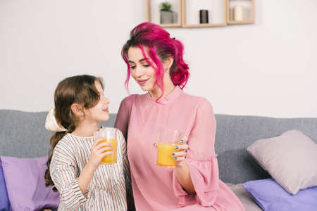 mother looks into the eyes of her little daughter and admires them while posing for the cameraの写真素材