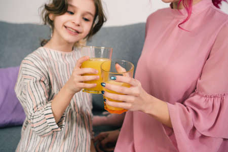 girls enjoy drinking delicious orange juice in the company of a photographerの写真素材