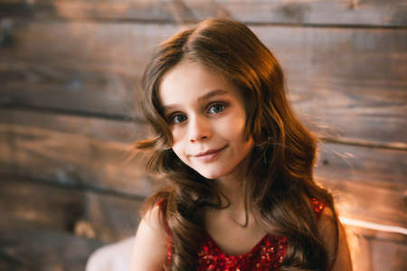 Little young model posing in the frame. She has blue eyes and brown hair.