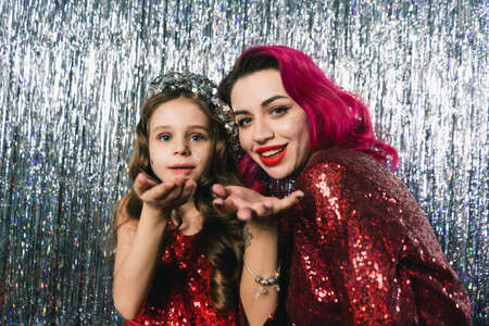 mom and daughter posing on a chic silver background during a New Years photo shoot