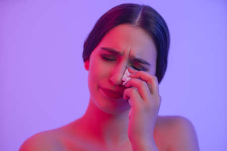 Tears of a young girl. Cry for not accepting yourself. Girl crying in neon light.