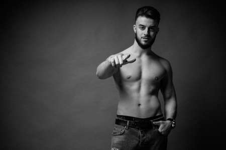 Black and white photo of a guy with a beard and dark hair showing a finger straight.の写真素材