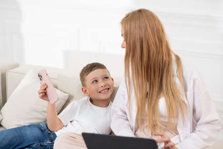 The son shows his mother that he has reached a new level in the telephone game.の写真素材