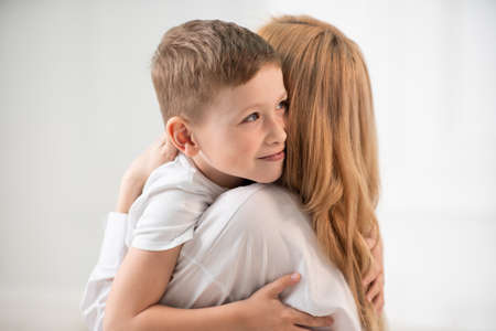 Hugs of mother and son. Strong volumes at home. The son hugs his mother.の写真素材