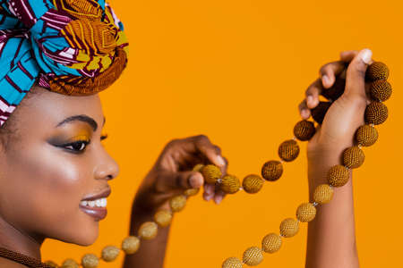 Black leather woman with bright makeup holding a beaded necklace. Traditional african accessories.の写真素材