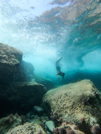 Man diving into the sea. View from inside the water.の写真素材