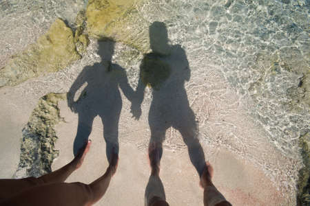 The shadow of a man and a woman in love reflected on the seashore.
