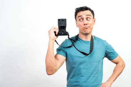 Smiling man showing a photo camera. Mid shot. White background.の写真素材