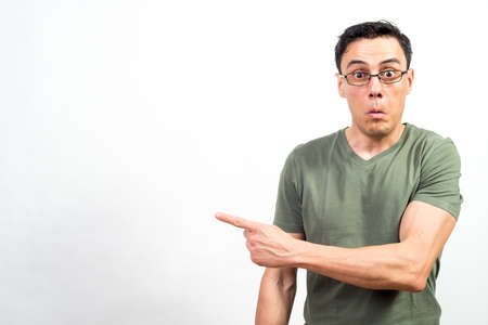 Shocked man with glasses pointing aside. Mid shot. White background.の写真素材