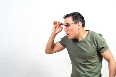 Man raising his glasses looking at something very surprised. Mid shot. White background.の写真素材
