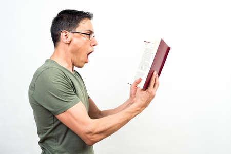 Man reading something that is surprising him a lot in a book. Mid shot. White background.の写真素材