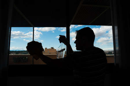 Man cleaning the windows at home. Full body.の写真素材