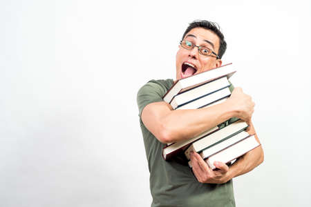 Very happy man with glasses holding a lot of books. Mid shot. White background.の写真素材