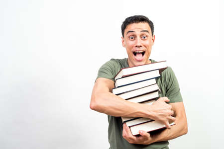 Very happy man holding a lot of books. Mid shot. White background.の写真素材