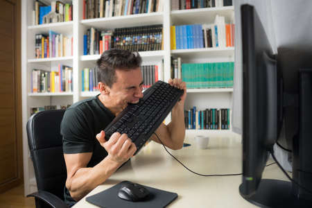 Seated man in a black shirt in front of the computer, hysterical because he does not understand...