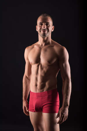 Athletic man in underwear. Mid shot. Black background.の写真素材