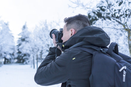 Photographer taking photos in a snowy landscape on a cold wintry day
