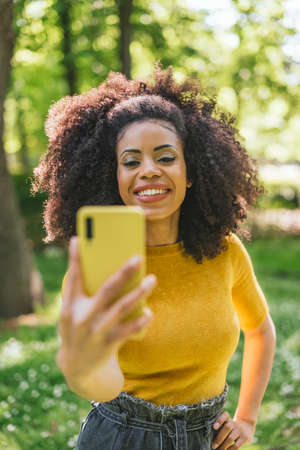 Pretty afro woman taking a selfie smiling.の写真素材