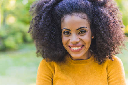Portrait of nice and happy afro girl in a garden. Close up.