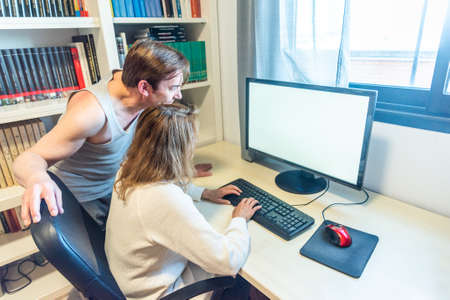 Mature aged couple with their back turned in front of the computerの写真素材