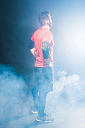 Side back view of an adult male with hands in waist looking forward.の写真素材